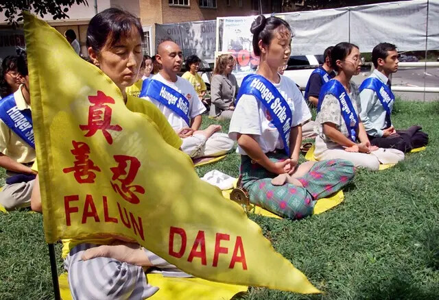 Los practicantes de Falun Gong meditan al iniciar el cuarto día de una huelga de hambre frente a la embajada china en Washington, el 20 de agosto de 2001. La huelga de hambre se dio en apoyo a 130 practicantes de Falun Gong que estaban en huelga de hambre en el campo de trabajos forzados de Masanjia, protestando por su injusta detención y trato brutal dentro del campo. (Stephen Jaffe/AFP/Getty Images)
