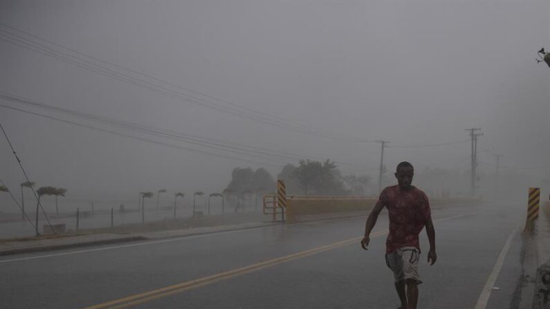 Un hombre camina en medio de una intensa ráfaga de viento y lluvia durante el paso de un huracán, en Nagua (República Dominicana). Imagen de archivo. EFE/ Orlando Barría