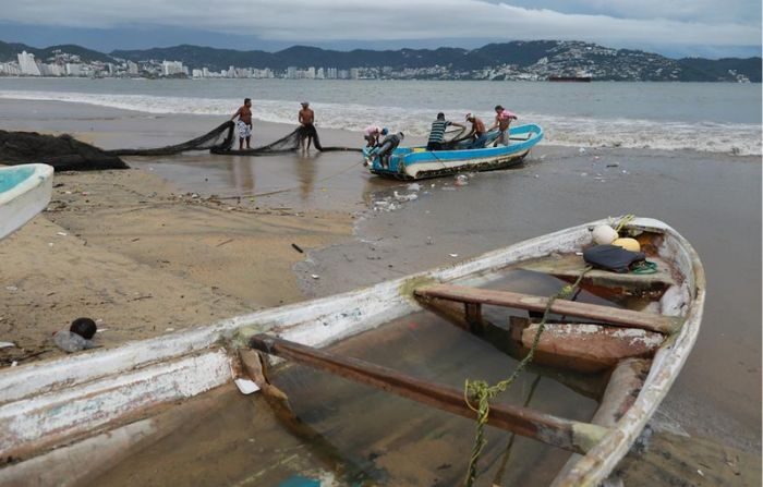 Un grupo de pescadores pone a salvo su embarcación en el balneario de Acapulco, estado de Guerrero, México. Imagen de archivo. (EFE/ David Guzmán)