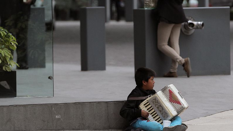 Fotografía de archivo que muestra a un niño mientras toca el acordeón para ganar un sustento, en una calle de la Ciudad de México, México. (EFE/Alex Cruz)