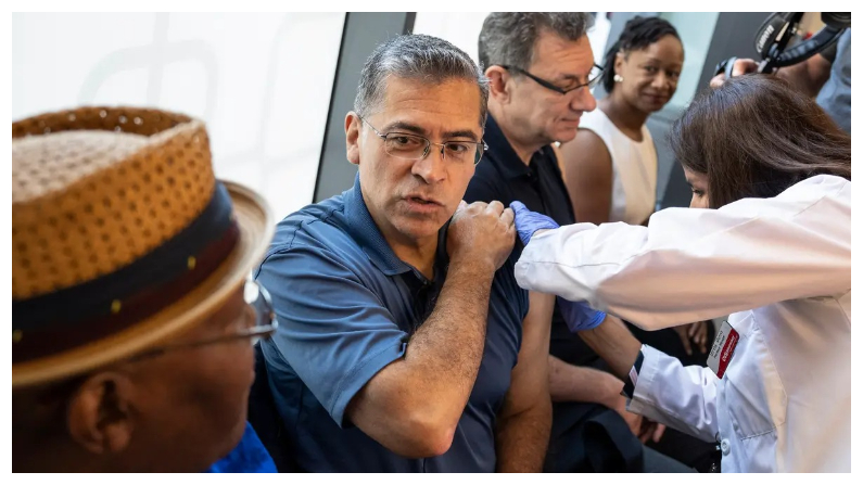 El secretario de Sanidad de EE.UU., Xavier Becerra, con el director general de Pfizer, Albert Bourla (centro), recibe una de las nuevas vacunas contra COVID-19 en un CVS de Washington el 20 de septiembre de 2023. (Drew Angerer/Getty Images)