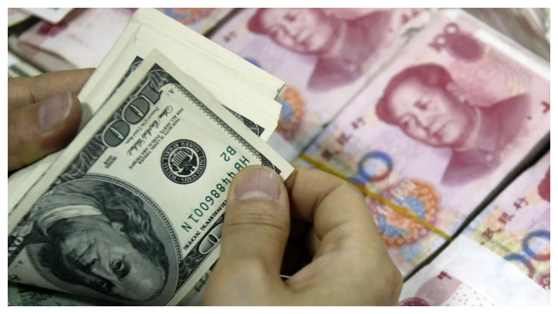 Billetes de dólares estadounidenses se contaban junto a pilas de billetes de 100 yuanes (RMB) en un banco de Huaibei, en la provincia oriental china de Anhui, el 24 de septiembre del 2013.(STR/AFP via Getty Images)