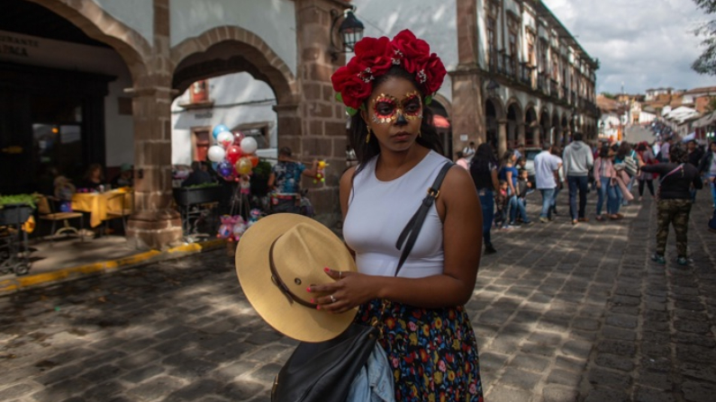 Una mujer con maquillaje de Día de los Muertos, pasea en el pueblo de Patzcuaro, estado de Michoacán, México. Fotografía de archivo. (EFE/Iván Villanueva)
