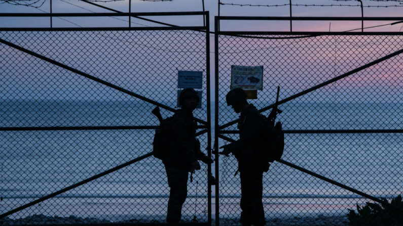 Esta foto tomada el 24 de abril de 2018 muestra a soldados surcoreanos de pie en una valla de seguridad frente a Corea del Norte, en la isla de Yeonpyeong, controlada por Corea del Sur, cerca de las aguas en disputa del Mar Amarillo al amanecer. (Ed Jones/AFP vía Getty Images)