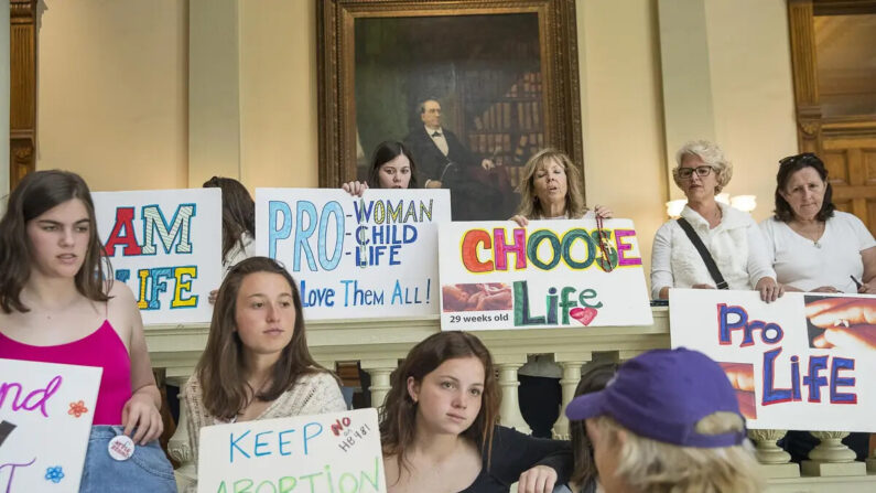 Manifestantes a favor del derecho al aborto y en contra mostrando sus carteles en el vestíbulo del edificio del Capitolio del Estado de Georgia durante el 35º día legislativo en el edificio del Capitolio del Estado de Georgia en el centro de Atlanta, el 22 de marzo de 2019. (Alyssa Pointer/Atlanta Journal-Constitution/Archivo vía AP)