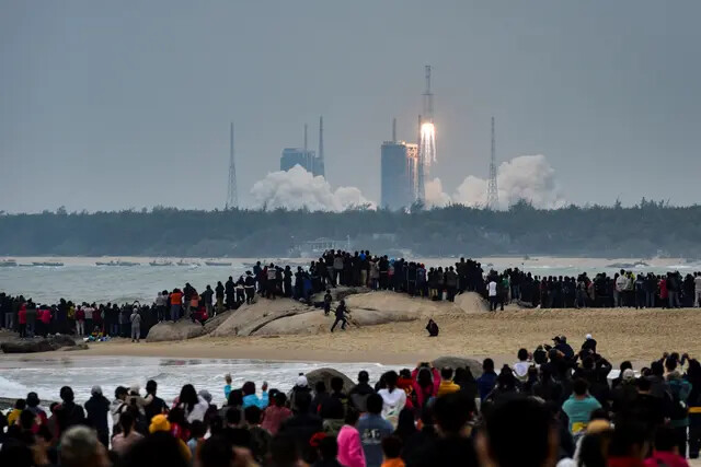La gente observa un cohete Long March-8 mientras despega del Centro de Lanzamiento Espacial de Wenchang, en la provincia de Hainan, en el sur de China, el 22 de diciembre de 2020. (AFP a través de Getty Images)
