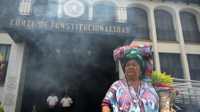 Una mujer indígena quema incienso frente a la Corte de Constitucionalidad durante la "Marcha de las Flores" para exigir la renuncia de funcionarios judiciales acusados de generar una crisis electoral en Guatemala antes de una segunda vuelta, en Ciudad de Guatemala (Guatemala) el 23 de julio de 2023. (Johan Ordonez/AFP vía Getty Images)