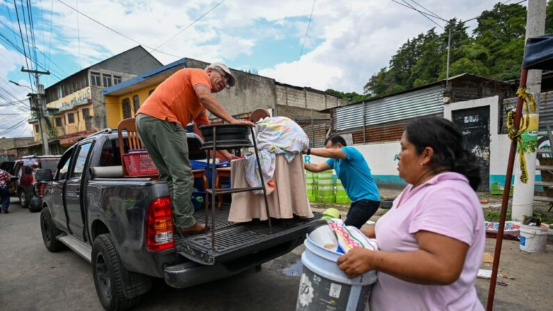 Personas evacuan sus pertenencias de sus casas derrumbadas por las fuertes lluvias en Villa Hermosa, municipio de San Miguel Petapa, Guatemala, el 28 de septiembre de 2023. (Johan Ordonez/AFP vía Getty Images)