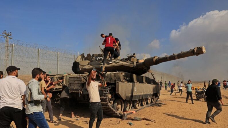 Palestinos toman el control de un tanque israelí tras cruzar la valla fronteriza con Israel desde Khan Yunis, en el sur de la Franja de Gaza, el 7 de octubre de 2023. (Said Khatib / AFP vía Getty Images)