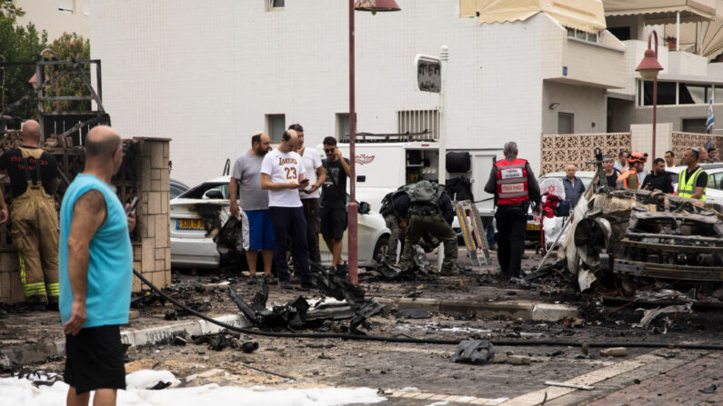 Un hombre observa una escena de coches quemados después de que un cohete disparado desde la Franja de Gaza cayera en una calle el 9 de octubre de 2023 en Ashdod, Israel. (Amir Levy/Getty Images)