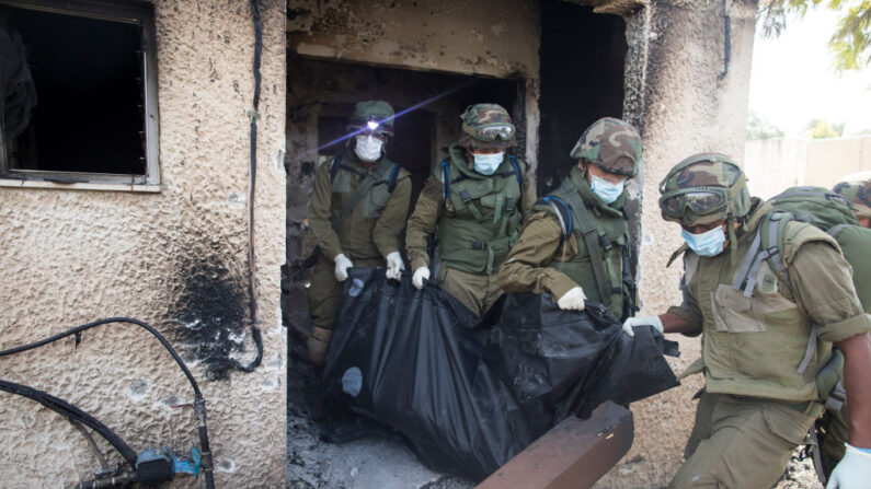 Soldados israelíes retiran el cuerpo de un civil, que fue asesinado días antes en un ataque de militantes palestinos en Kfar Aza, Israel, cerca de la frontera con Gaza, el 10 de octubre de 2023. (Amir Levy/Getty Images)