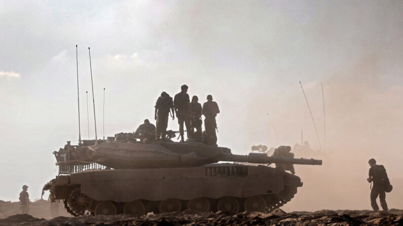 Tropas israelíes sobre un tanque en un campo cerca del kibutz Beeri, en el sur de Israel, el 14 de octubre de 2023. (Thomas Coex/AFP vía Getty Images)