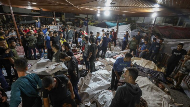 Varias personas se reúnen en torno a los cadáveres de los palestinos muertos en una explosión en el hospital Ahli Arab, en el centro de Gaza, tras ser trasladados al hospital Al-Shifa, el 17 de octubre de 2023. (Dawood Nemer/AFP vía Getty Images)