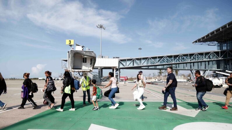 Varias personas suben a un avión tras el paso del huracán Otis en el Aeropuerto Internacional de Acapulco, México, el 27 de octubre de 2023. (RODRIGO OROPEZA/AFP via Getty Images)