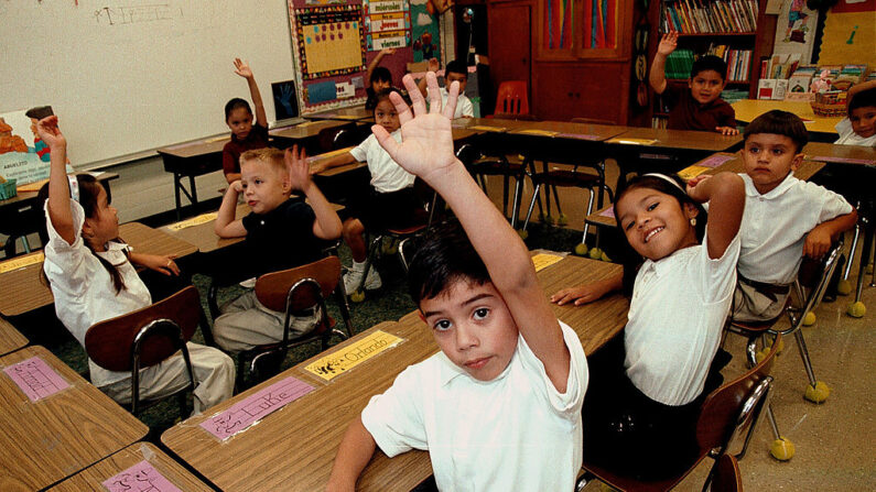 Estudiantes hispanos monolingües levantan la mano para responder una pregunta durante una clase impartida en español en la Escuela Primaria Birdwell el 11 de septiembre de 2003 en Tyler, Texas. (Mario Villafuerte/Getty Images)