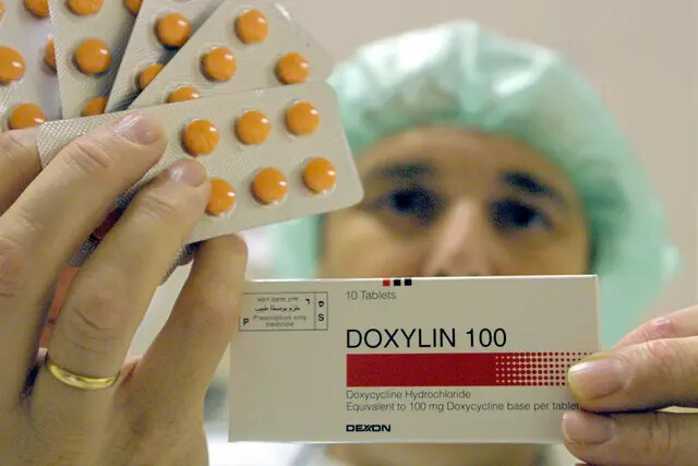 Un trabajador de la planta farmacéutica Dexxon sostiene un paquete de su medicamento antibiótico Doxylin, en la ciudad israelí de Or Akiva, el 8 de noviembre de 2001. Doxylin es el nombre comercial del clorhidrato de doxiciclina, uno de los tres antibióticos eficaces para combatir las infecciones por ántrax. (David Silverman/Getty Images)
