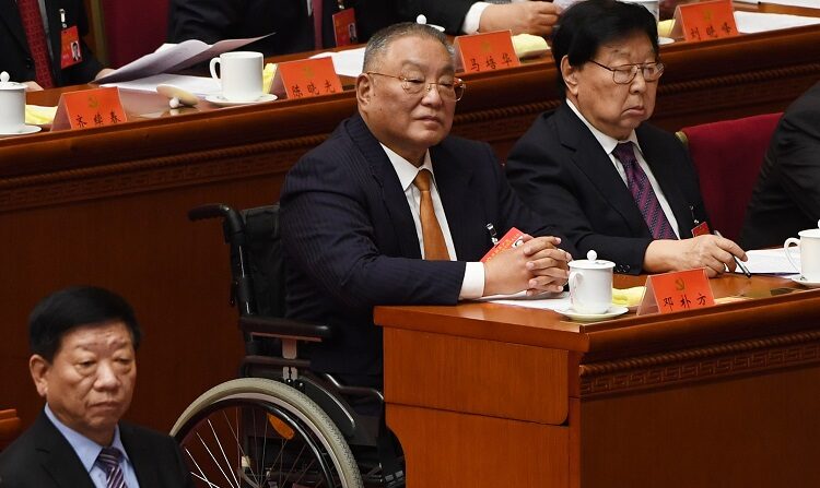 Deng Pufang (C), hijo del ex dirigente Deng Xiaoping, sentado en su silla de ruedas durante la sesión de clausura del XIX Congreso del Partido Comunista en el Gran Salón del Pueblo de Beijing, el 24 de octubre de 2017. (GREG BAKER/AFP via Getty Images)