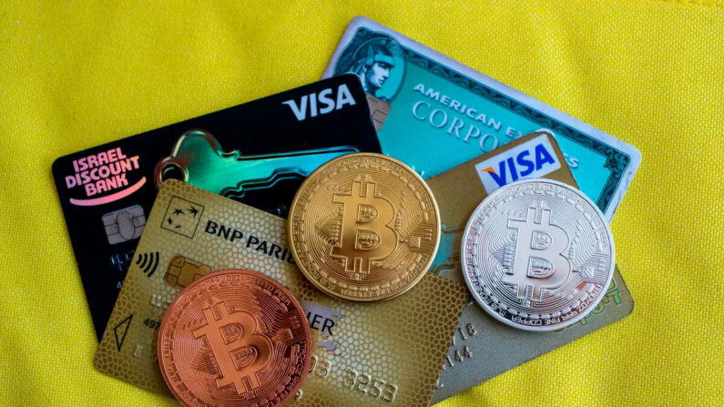 Una imagen muestra una representación visual de la criptomoneda digital Bitcoin junto a tarjetas Visa, en la tienda "Bitcoin Change" en la ciudad israelí de Tel Aviv el 6 de febrero de 2018. (Jack Guez/AFP vía Getty Images)