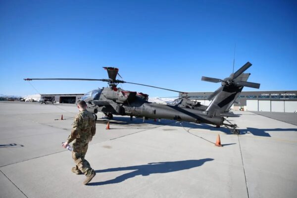 Un trabajador de mantenimiento pasa junto a un helicóptero AH-64 Apache en Kearns, Utah, el 4 de marzo del 2020. (George Frey/Getty Images)