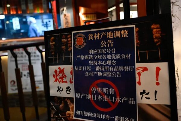 Un cartel en el que se lee "Suspender la venta de todos los productos pesqueros importados de Japón" en una zona de restaurantes japoneses en Pekín el 27 de agosto del 2023. (Pedro Pardo/AFP vía Getty Images)
