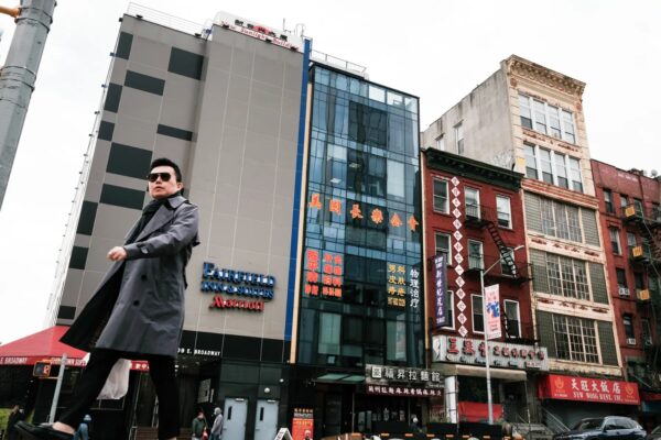 Varias personas caminan junto a un edificio (C), sospechoso de ser una comisaría secreta del régimen chino, en el barrio chino de Nueva York el 18 de abril del 2023. (Spencer Platt/Getty Images)