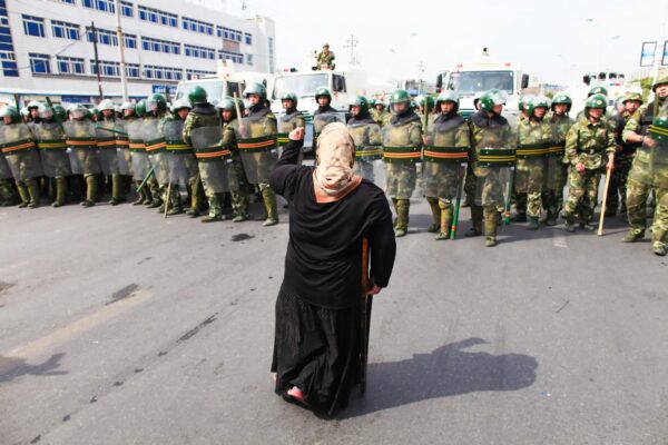 Una mujer uigur protesta frente a policías en una calle de Urumqi, capital de la región autónoma uigur de Xinjiang, China, el 7 de julio del 2009. (Guang Niu/Getty Images)