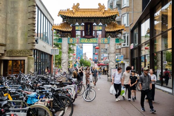 Varias personas caminan cerca de la puerta de Chinatown en La Haya, Países Bajos, el 18 de julio de 2023. (Lavinia Savu/The Epoch Times)