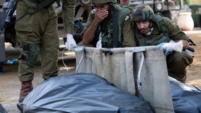 Un soldado de las FDI reacciona y se cubre la cara antes de retirar el cuerpo de un civil muerto días antes en un ataque de militantes de Hamás el 10 de octubre de 2023, en Kfar Aza, Israel. (Alexi J. Rosenfeld/Getty Images)