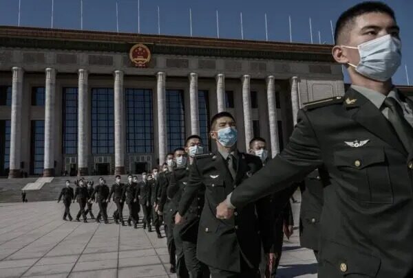 Soldados chinos del Ejército Popular de Liberación llevan máscaras protectoras mientras marchan después de una ceremonia que conmemora el 70 aniversario de la entrada de China en la Guerra de Corea, el 23 de octubre del 2020, en el Gran Salón del Pueblo en Pekín, China. (Kevin Frayer/Getty Images)