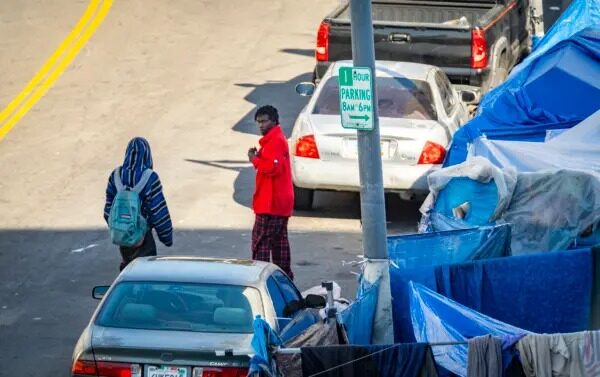 Varios hombres caminan cerca de un campamento de personas sin hogar en el centro de Los Ángeles el 6 de enero del 2022. (John Fredricks/The Epoch Times)