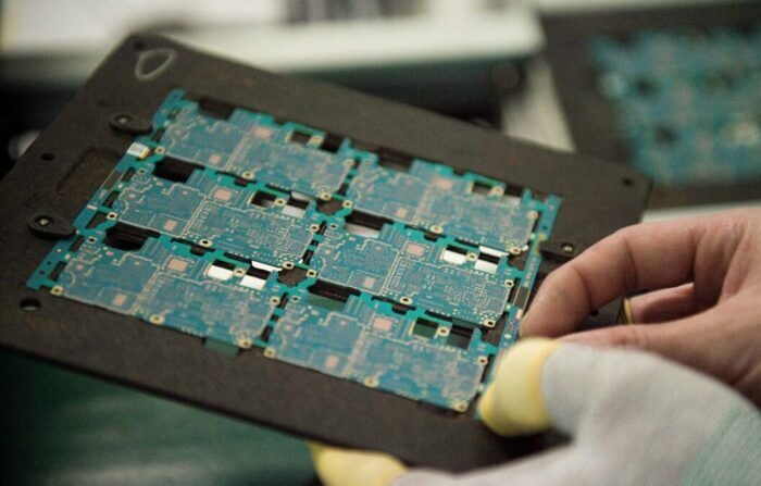 Circuitos de componentes de chips de smartphones son manipulados por un trabajador en una fábrica de Dongguan, China, el 8 de mayo de 2017. (Nicolas Asfouri/AFP vía Getty Images) 