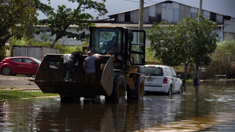 Personal de emergencias rescata en una grúa a un empleado público que perdió su auto debido a las inundaciones por las fuertes lluvias, en la barriada Juana Matos en Cataño (Puerto Rico). Imagen de archivo. EFE/ Thais Llorca