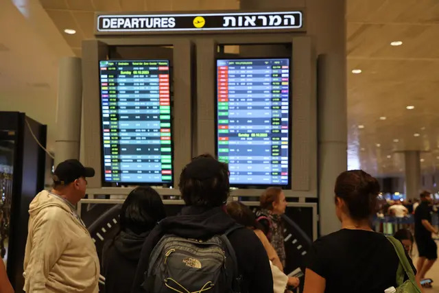 Pasajeros miran un tablero de salidas en el aeropuerto Ben Gurion, cerca de Tel Aviv, Israel, el 7 de octubre de 2023, mientras se cancelan los vuelos debido a los ataques sorpresa de Hamás. (GIL COHEN-MAGEN/AFP vía Getty Images)