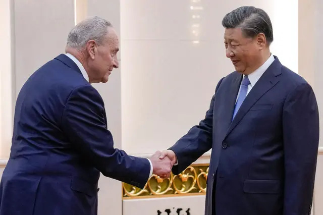 El líder de la mayoría del Senado de EE.UU., Chuck Schumer (D-N.Y.) (L), es saludado por el líder chino Xi Jinping antes de su reunión bilateral en Beijing el 9 de octubre de 2023. (Andy Wong/POOL/AFP vía Getty Images)
