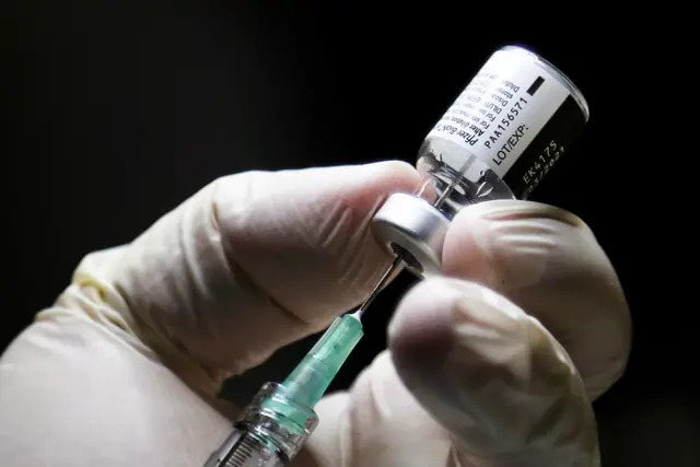 Un trabajador sanitario prepara una dosis de la vacuna contra el COVID-19 de Pfizer/BioNTEch en el Instituto Michener, en Toronto, Canadá, el 14 de diciembre de 2020. (Carlos Osorio/POOL/AFP vía Getty Images)