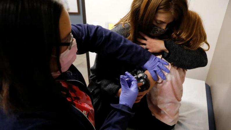 Una niña de 6 años es consolada por su madre mientras recibe su primera dosis de la vacuna contra el Covid-19 de Pfizer-BioNTech en Novi, Michigan, el 3 de noviembre de 2021. (Jeff Kowalsky/AFP vía Getty Images)