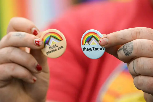 Un activista sujeta pins sobre los pronombres de género en el campus de la Universidad de Wyoming en Laramie, Wyoming, el 13 de agosto de 2022. (Patrick Fallon/AFP vía Getty Images)