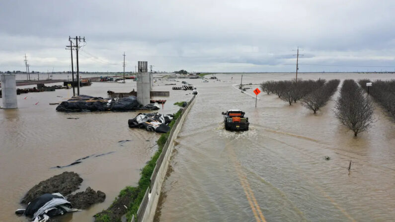 Una imagen aérea muestra un camión mientras atraviesa una carretera inundada junto a tierras de cultivo del Valle Central a lo largo del río Tule en el condado de Tulare durante una tormenta cerca de Corcoran, California, el 21 de marzo de 2023. (Patrick T. Fallon/AFP vía Getty Images)