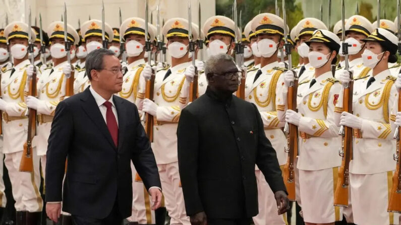 El primer ministro de las Islas Salomón, Manasseh Sogavare (D), y el primer ministro chino, Li Qiang, inspeccionan la guardia de honor durante una ceremonia de bienvenida en el Gran Salón del Pueblo de Beijing, China, el 10 de julio de 2023. (Andy Wong/POOL/AFP vía Getty Images)