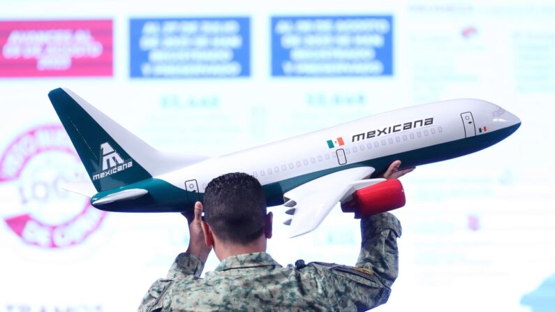 Fotografía de archivo de un militar del ejército que acomoda una maqueta de un avión de Mexicana durante una conferencia de prensa en el Palacio Nacional, en Ciudad de México, México. (EFE/Sáshenka Gutiérrez)