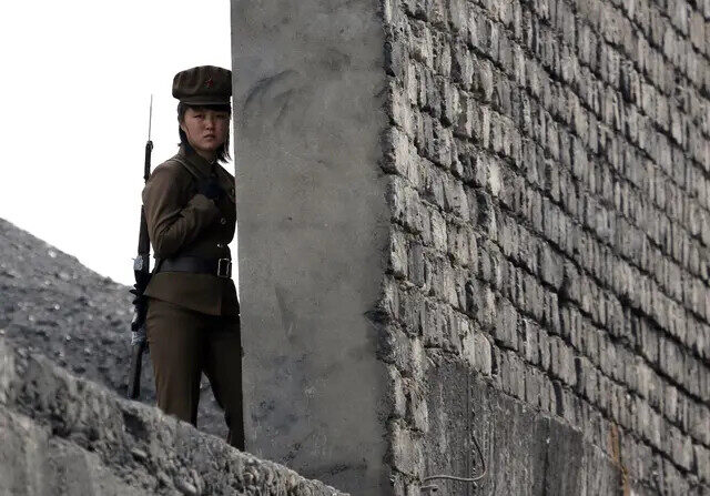Una soldado norcoreana patrulla la orilla del río Yalu que separa la ciudad norcoreana de Sinuiju de la ciudad fronteriza china de Dandong, en la provincia nororiental china de Liaoning, el 26 de abril de 2014. (STR/AFP vía Getty Images)