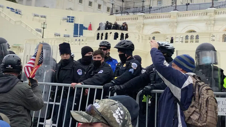 Agentes de la Policía del Capitolio de EE.UU. intentan mantener la barrera en el frente oeste del Capitolio el 6 de enero de 2021. (Steve Baker/Especial para The Epoch Times)