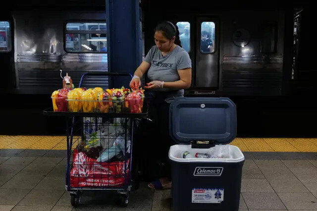 Una mujer vende caramelos y otros artículos en una estación de metro de Nueva York el 18 de agosto de 2023. Más de 70.000 solicitantes de asilo han llegado a Nueva York desde el año pasado, según el Ayuntamiento, y muchos se han dedicado a vender artículos en las calles y el metro de la ciudad. (Spencer Platt/Getty Images)