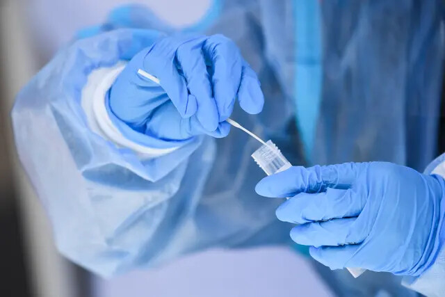 Un trabajador de la salud coloca un hisopo de prueba en una solución para una prueba de Covid-19 en un centro de pruebas en Hawthorne, California, el 18 de enero de 2022. (Patrick T. Fallon/AFP vía Getty Images)