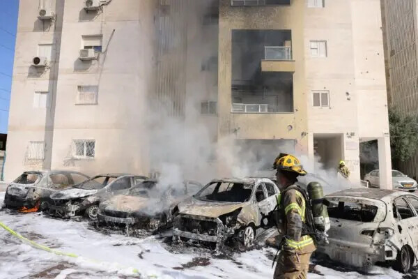 Equipos de bomberos israelíes apagan el incendio de un estacionamiento afuera de un edificio residencial luego de un ataque con cohetes desde la Franja de Gaza, en la ciudad de Ashkelon, en el sur de Israel, el 7 de octubre de 2023. (Ahmad Gharabli/AFP vía Getty Images)
