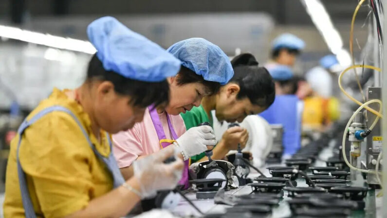 Empleados trabajan en una línea de montaje que produce altavoces en una fábrica en Fuyang, en la provincia oriental de Anhui, China, el 30 de junio de 2023. (STR/AFP a través de Getty Images)
