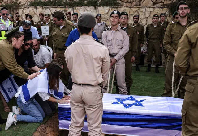 Familiares del soldado franco-israelí Eli Valentin Ghenassia, muerto en combate en el kibutz Beeri durante una infiltración de militantes de Hamás, lloran durante su funeral en el cementerio del Monte Herzl de Jerusalén el 12 de octubre de 2023. (Ronaldo Schemidt/AFP/Getty Images)