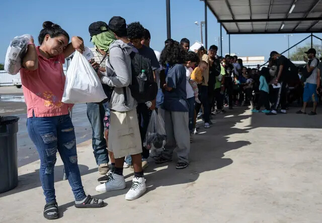 Inmigrantes ilegales hacen fila mientras esperan un autobús a Chicago para sacarlos de Eagle Pass, Texas, el 26 de septiembre de 2023. (Andrew Caballero-Reynolds/AFP vía Getty Images)
