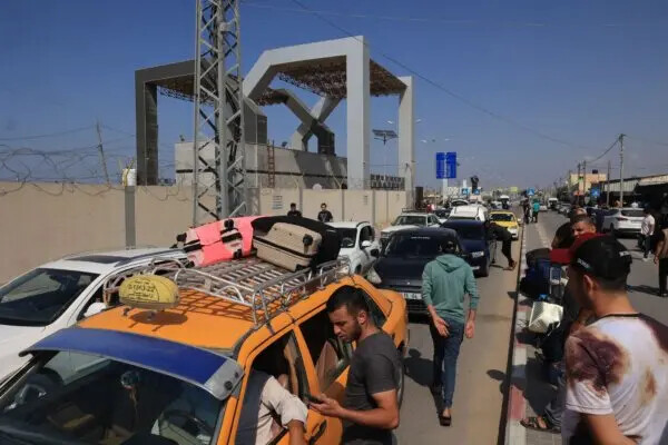 Palestinos con pasaportes extranjeros llegan a la puerta de Rafah con la esperanza de cruzar a Egipto mientras continúan los ataques de Israel contra la Franja de Gaza, el 14 de octubre de 2023. (Said Khatib/AFP vía Getty Images)