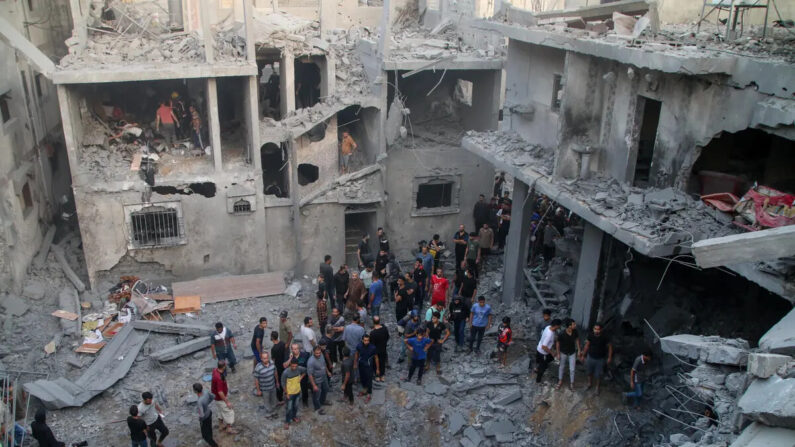 Los servicios de emergencia palestinos y ciudadanos locales buscan víctimas en edificios destruidos durante los ataques aéreos israelíes en el sur de la Franja de Gaza, en Khan Yunis, Gaza, el 19 de octubre de 2023. (Ahmad Hasaballah/Getty Images)
